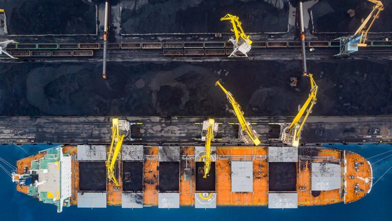 Un buque carga carbón en un puerto.