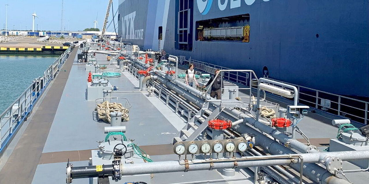 Una barcaza de biocombustibles suministra fuel a un car carrier.