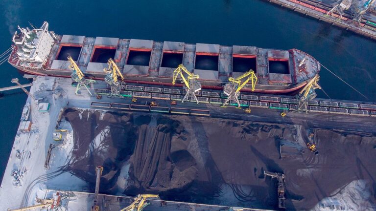Un buque granelero carga carbón en una terminal portuaria.