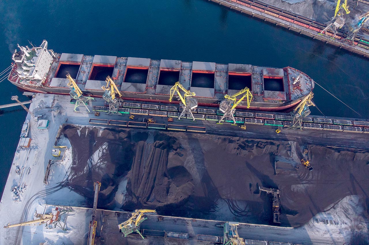Un buque granelero carga carbón en una terminal portuaria.