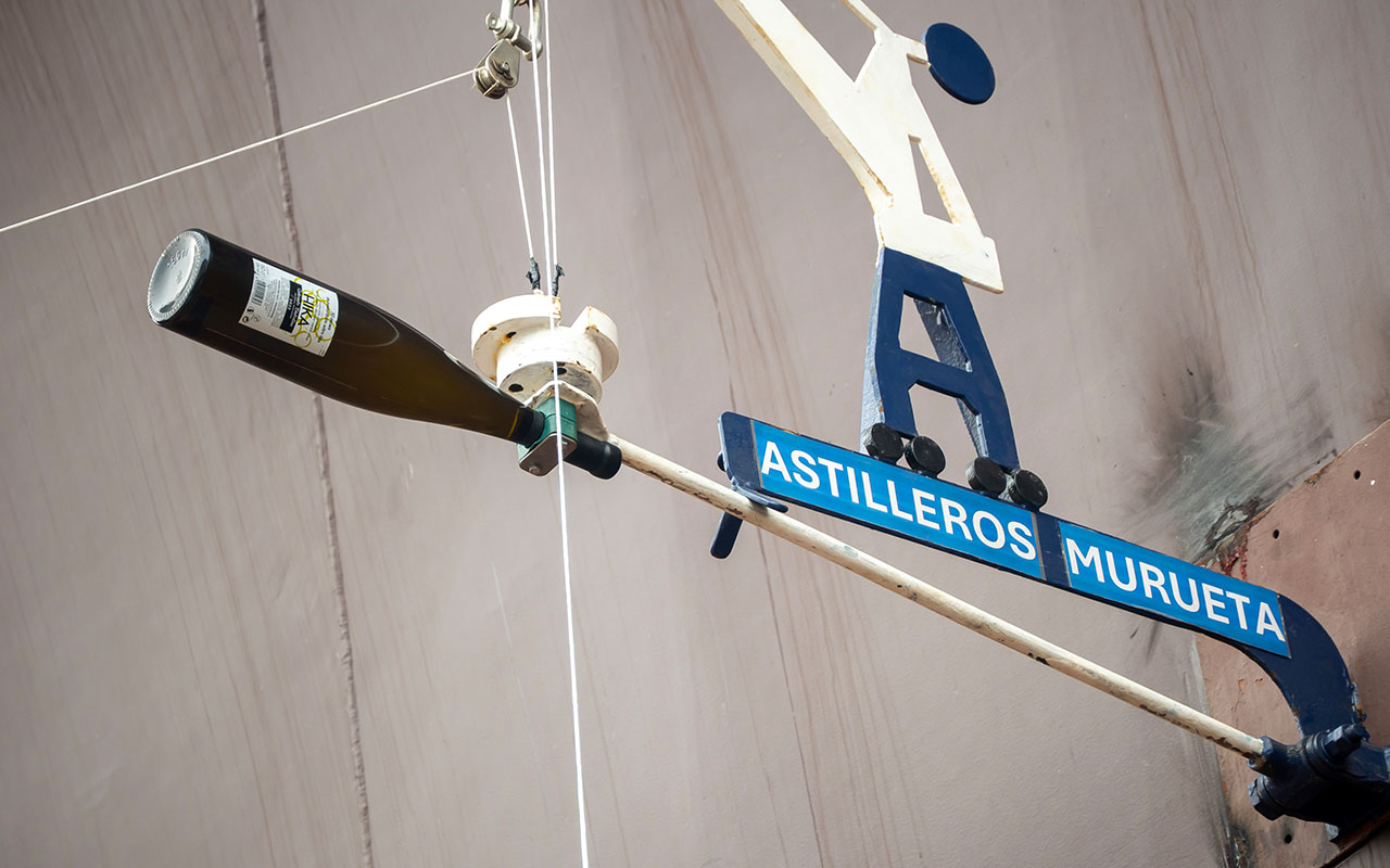 La tradicional botella de 'txakoli' de Guetaria para el bautizo del nuevo buque.