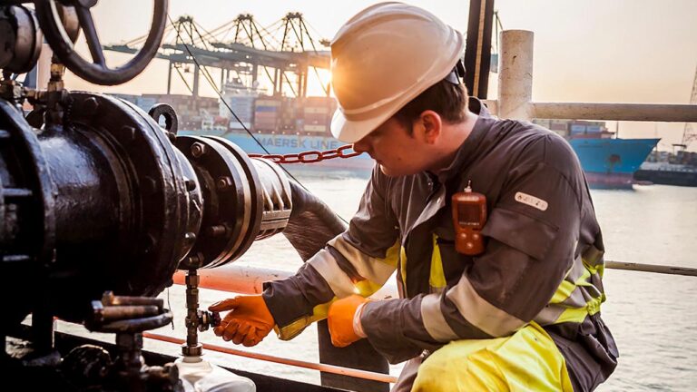 Un operario toma una muestra de combustible durante una operación de bunkering.