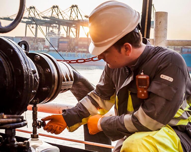 Un operario toma una muestra de combustible durante una operación de bunkering.