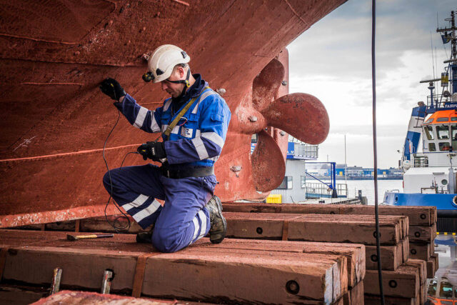 Un operario inspecciona el casco de un buque.
